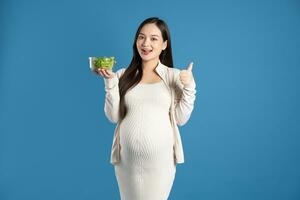 Portrait of pregnant asian woman, isolated on blue background photo