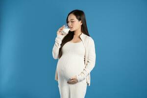 Portrait of pregnant asian woman, isolated on blue background photo