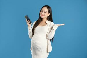 Portrait of pregnant asian woman, isolated on blue background photo