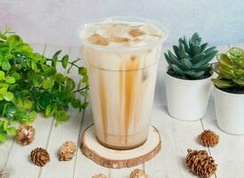 Hand-fried brown sugar milk tea served om disposable glass isolated on wooden board top view of hong kong drink photo