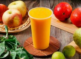 Fresh mango juice with raw fruits served in glass isolated on table top view of morning vitamins drink photo