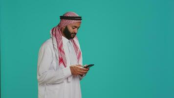 árabe pessoa cumprimento pessoas em chamar, acenando e pegando acima com amigos em controlo remoto rede conexão. meio Oriental adulto dentro tradicional islâmico roupas discutindo em teleconferência. video