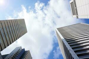 Look up view and crop of office building on bright blue sky background. with space for texts photo