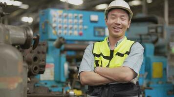 arbeiders fabriek Aziatisch Mens werken Bij zwaar machine. groep van mensen in werking in voorkant van motor vervaardigd Bij industrieel fabriek fabriek. slim industrie arbeider werkend. vrouw glimlachen en gelukkig. video