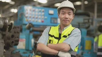 arbeiders fabriek Aziatisch Mens werken Bij zwaar machine. groep van mensen in werking in voorkant van motor vervaardigd Bij industrieel fabriek fabriek. slim industrie arbeider werkend. vrouw glimlachen en gelukkig. video