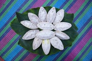 Bangladeshi Traditional Aush or Porangi Rice Special  Delicious hand-made Chitoi Pitha Decorated on the green leaf Recipe photo