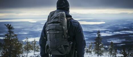 AI generated Back view of a climber standing atop a snowy peak, embodying the success and fulfillment of a challenging winter hike. photo