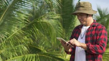ung jordbrukare använda sig av tabletter till övervaka kokosnötter video