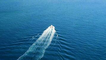 antenne visie van snel boot Aan een diep blauw zee met wit golven video