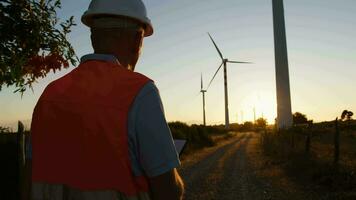 Sénior ingénieur chèques le correct fonctionnement de vent turbines avec le feuille video