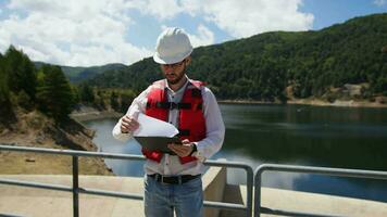 ingénieur avec blanc casque vérifier entretien de le barrage video