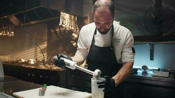 Chef prepares almond pesto with blender into restaurant kitchen video