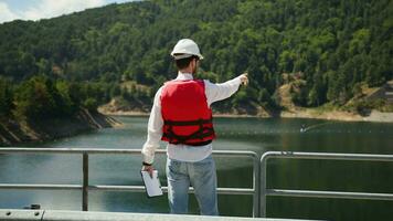 Engineer pointing to the edge structures on the artificial dam video