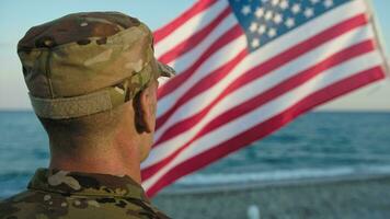 soldado dentro uniforme em pé às atenção Próximo para a americano bandeira video