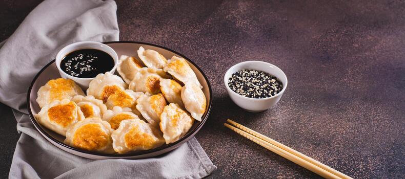freído en sarten empanadillas con soja salsa en un plato en el mesa web bandera foto