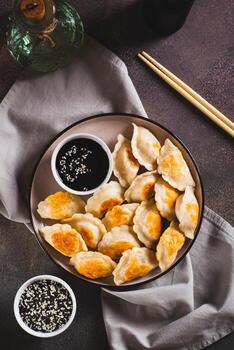 crujiente frito empanadillas con soja salsa y sésamo semillas en un plato parte superior y vertical ver foto