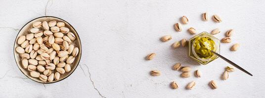 Jar with pistachio cream butter and pistachios on the table top view web banner photo