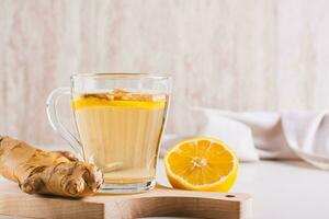 Homeopathic ginger lemon tea in a cup on the table photo