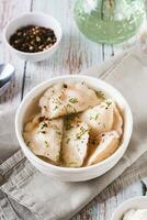 Soup with dumplings, herbs, spices and sour cream in a bowl on the table vertical view photo