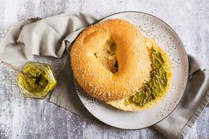 cerca arriba de rosquilla con pistacho crema mantequilla para desayuno en un plato en el mesa parte superior ver foto