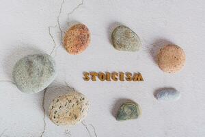 Concept stoicism word made from letters and stones around on a gray background top view photo