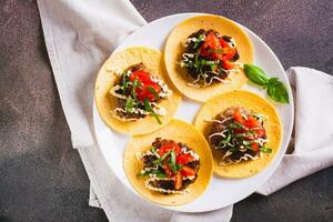 cerca arriba de aplastar hamburguesa tacos con Tomates, salsa y hierbas en un plato en el mesa parte superior ver foto