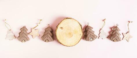 Tree trunk cut, knitted and wooden fir tree on pink background top view web banner photo