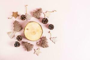 Handmade knitted trees, christmas decorations and pine cones around a cut tree top view photo