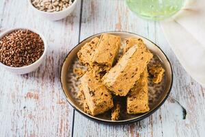 Pieces of halva with flax seeds on a plate on the table photo