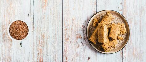 Pieces of halva with flax seeds on a plate on the table top view web banner photo