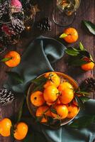 Fresh tangerines with leaves on a plate on the Christmas table top and vertical view photo