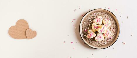 Homemade white chocolate candy hearts with icing on a plate on the table top view web banner photo