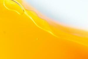 Close up bright orange juice splash texture for health and nature waves, Beautiful waves curve and little bubbles smooth for garphic design and background photo