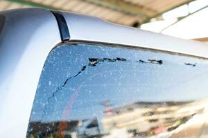 The back window of the pickup truck was broken. Cracked windshield photo