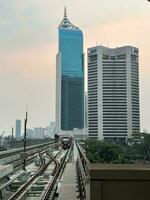 Jakarta, Indonesia, 2023 - Evening Skyline with High-Rise Buildings and Rail Transportation photo