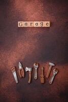 Tools and inscriptions symbolizing repairs or a garage and its attributes on a plain background photo