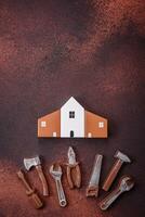 Repair or home improvement tools and a house model on a plain background photo