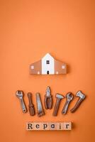 Repair or home improvement tools and a house model on a plain background photo