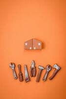 Repair or home improvement tools and a house model on a plain background photo