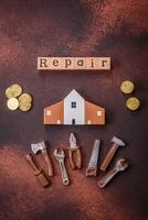 Repair or home improvement tools and a house model on a plain background photo