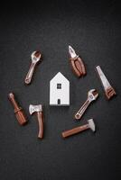 Repair or home improvement tools and a house model on a plain background photo