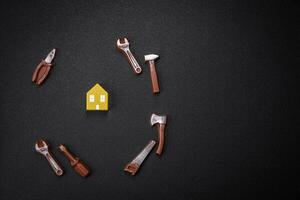 Repair or home improvement tools and a house model on a plain background photo