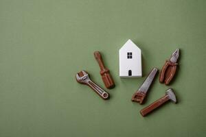 Repair or home improvement tools and a house model on a plain background photo