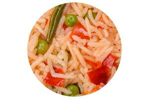 Delicious boiled rice with vegetables peppers, green peas, salt, spices and herbs photo