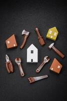 Repair or home improvement tools and a house model on a plain background photo