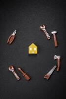 Repair or home improvement tools and a house model on a plain background photo