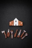 Repair or home improvement tools and a house model on a plain background photo