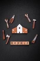 Repair or home improvement tools and a house model on a plain background photo