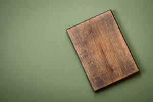 Empty wooden rectangular cutting board on a plain background, flatley with copy space photo