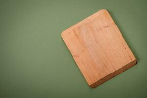 Empty wooden rectangular cutting board on a plain background, flatley with copy space photo